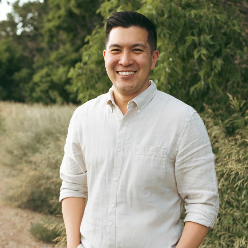 Dr. Isaac standing while looking at the camera and smiling.